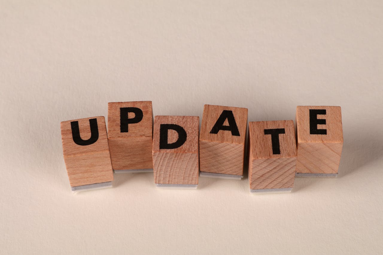 Wooden letter blocks arranged to spell Update on a beige surface.
